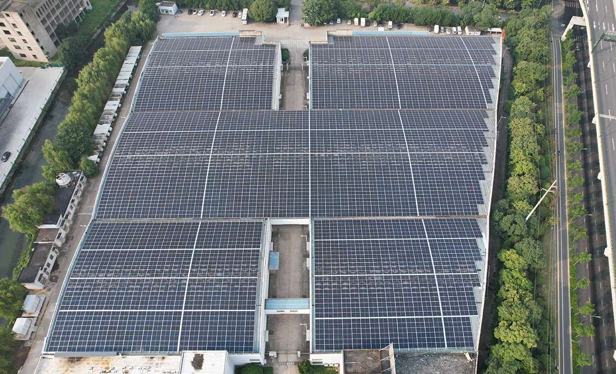 A large industrial rooftop solar project installed across multiple factory buildings, demonstrating optimized solar coverage and energy self-sufficiency for urban manufacturing.